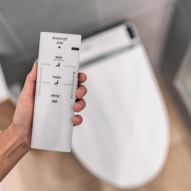 Smart japanese bidet automated toilet washlet with remote for easing cleaning rinsing with water without using toilet paper. at home bathroom modern lifestyle